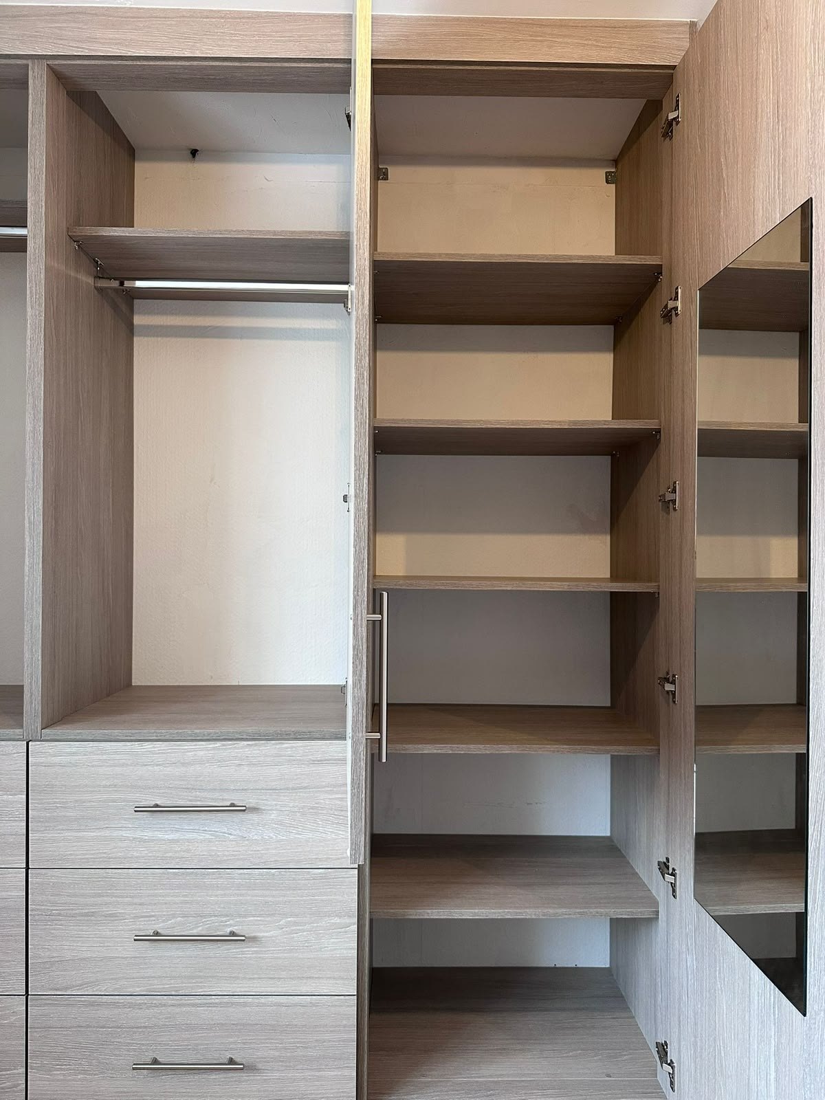 Inside the Feltham wardrobe showing a full-height hanging section next to a column of adjustable shelves
